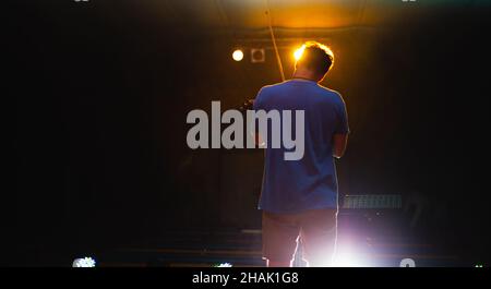 View from the back of a man playing the violin on stage Stock Photo