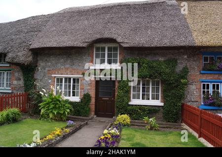Adare, County Limerick, Ireland: a traditional Irish thatched cottage with front garden Stock Photo
