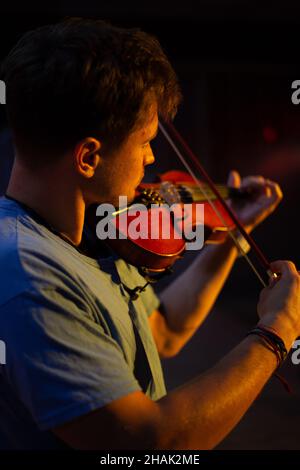 A man plays the violin on the stage of close Stock Photo