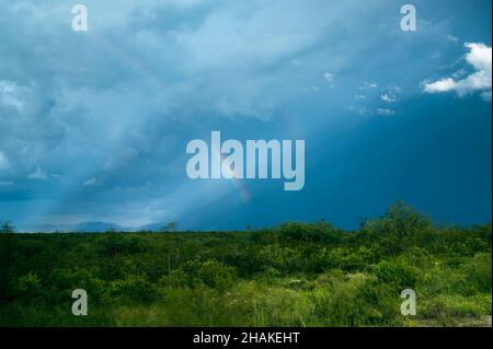 Rainbow dramatic stormy sky in blue and green colors Stock Photo
