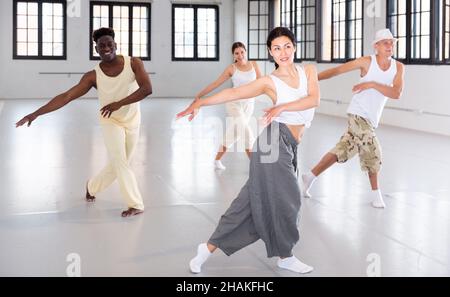 Group of dancers training modern dance moves in ball room Stock Photo