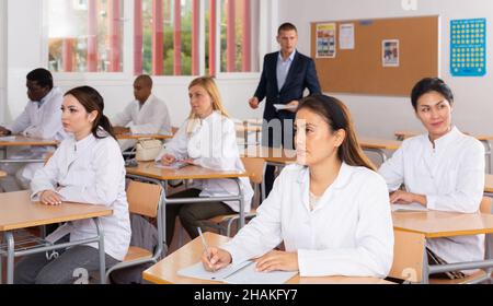 Medical students writing in notepads during lesson Stock Photo
