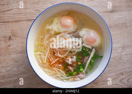 Soup bowl, soup noodle pork white noodle with vietnamese pork soft boiled eggs and bean sprout vegetable spring onion in soup bowl on wooden table, Th Stock Photo