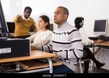 Young adult man studying in computer class Stock Photo