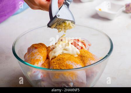 chicken drumsticks in a cup add garlic Stock Photo