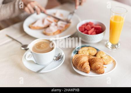 Coffee and croissant for breakfast served at a table. Stock Photo