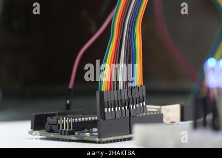 Jumper wires connectors are connected to the development board. Colored cables for making electronic circuits Stock Photo