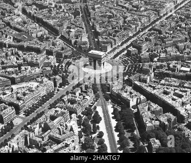 Paris - low level aerial photo centered on the Arc de Triomphe during Occupation, 1944. The view of the streets of Paris as they radiate out from the Arc de Triomphe was taken from a low flying US airplane using a photo method called low-level-oblique. The camera position is roughly west of the Arc de Triomphe and the street that points most to photographer is Avenue Foch. Avenue des Champs-Elysees runs from the center to the upper right corner of the image. There are less than thirty motor vehicles on the circular Place de l'Etoile around the famous Arch. Stock Photo