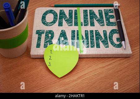 Conceptual caption Online Training. Word for Take the education program from the electronic means Plain Blank Open Notebooks With Stack Of Pens Stock Photo