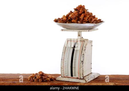 raisins on old metal scales on wooden beams, isolated Stock Photo