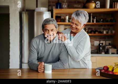 Portrait of smiling elderly biracial couple enjoying retirement in their modern home. Indoors, healthy lifestyle. Stock Photo