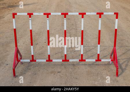 Red and white steel fence barrier restricted area Stock Photo