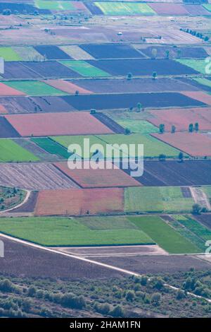 Aerial view of harvested fields and green meadows with a winding dirt ...