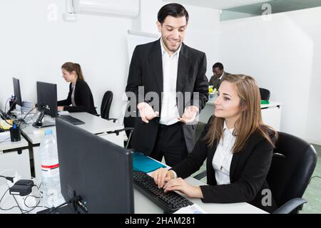 Bearded man flirting with woman working in office Stock Photo