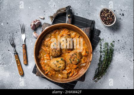 Cutlets or Fish balls with tuna in tomato sauce. Gray background. Top view Stock Photo