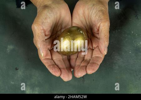 Woman hands holding golden egg Stock Photo