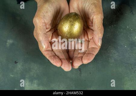 Woman hands holding golden egg Stock Photo
