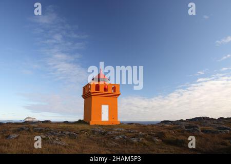 The tiny, orange Hafnarnes lighthouse of eastern Iceland Stock Photo