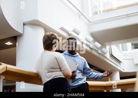 Two students talking in library Stock Photo