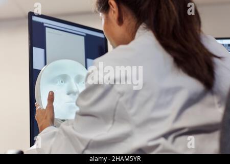 Female engineer building robot with human face Stock Photo