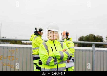 Engineers in reflective clothing standing on bridge Stock Photo