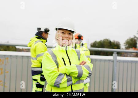Engineers in reflective clothing standing on bridge Stock Photo