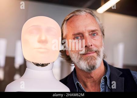 Portrait of senior man with robot voice assistant Stock Photo