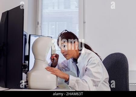 Female engineer building robot at work station Stock Photo