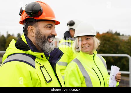 Engineers in reflective clothing talking Stock Photo