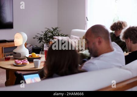 Family sitting on sofa in living room Stock Photo