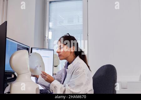 Female engineer building robot at work station Stock Photo
