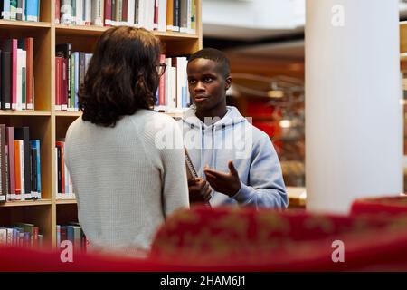 Two students talking in library Stock Photo