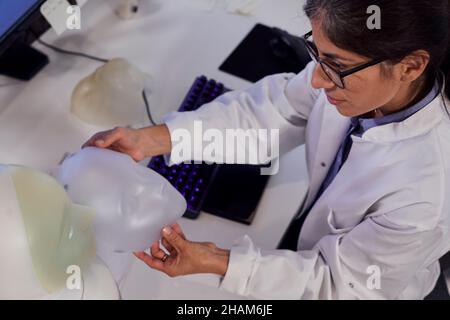 Female engineer building robot with human face Stock Photo