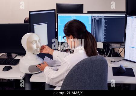 Female engineer building robot with human face Stock Photo