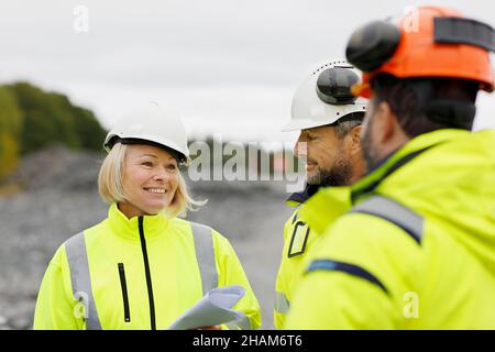 Engineers in reflective clothing discussing plans Stock Photo