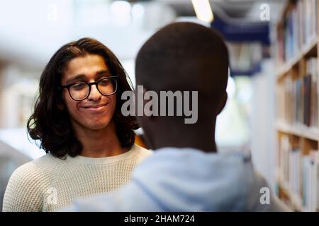 Two students talking in library Stock Photo