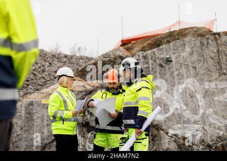 Engineers in reflective clothing discussing plans Stock Photo