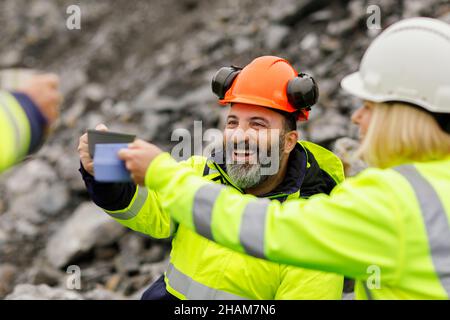 Engineers in reflective clothing having hot drink Stock Photo