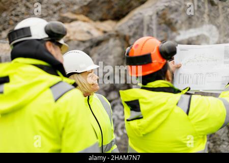 Engineers in reflective clothing discussing plans Stock Photo