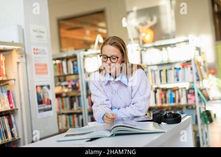 Young woman studying in library Stock Photo