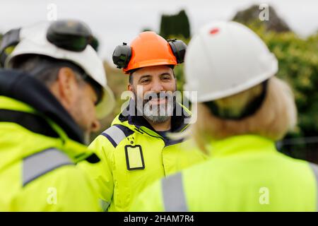 Engineers in reflective clothing talking Stock Photo