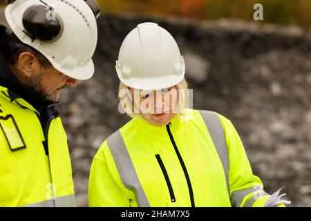 Engineers in reflective clothing looking at plans Stock Photo