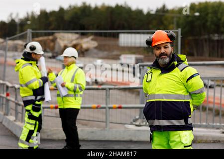 Engineers in reflecting clothing at building site Stock Photo