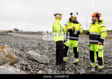 Engineers in reflective clothing having hot drink Stock Photo
