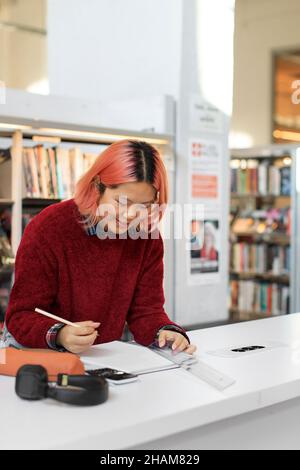 Young woman studying in library Stock Photo