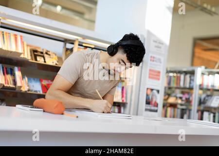Young man studying in library Stock Photo