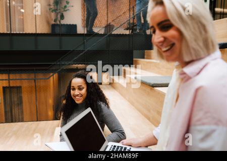 Smiling female coworkers at corridor Stock Photo