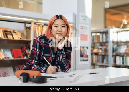Young woman studying in library Stock Photo