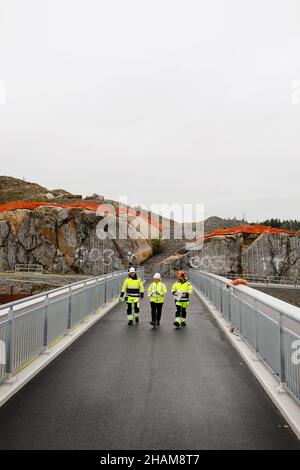 Engineers in reflective clothing walking on bridge Stock Photo
