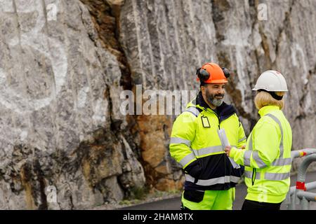 Engineers in reflecting clothing talking at building site Stock Photo